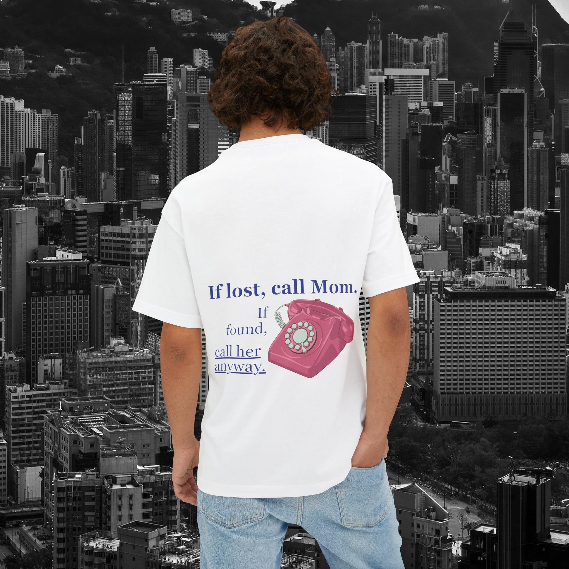 A man wearing unisex oversized "If Lost, Call Mom. If Found, Call Her Anyway." white t-shirt at back view - Unique Fashion Tops, funny and heartfelt quote design for adulthood and Mother's day - front and back print - Oh Mine Words.