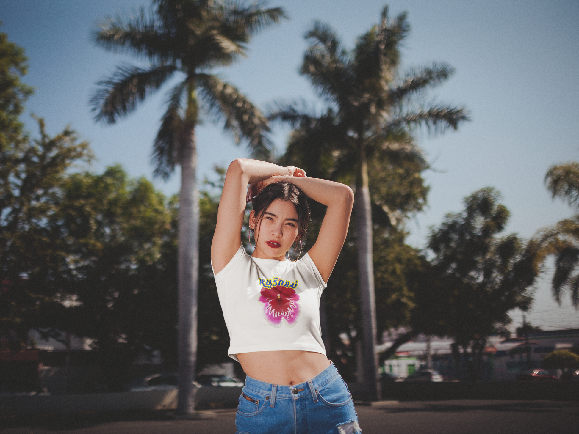 A women wearing "หนูรักแม่ เบบี้ที (ดอกกล้วยไม้) - I Love Mom Baby Tee (Orchid)" white baby tee/ crop tops/ tank tops/ slim fit tee at front view - Unique fashion tops for casual wear or Mother's day - Thai twist Y2k style - Front and Back printed T-shirt - Oh Mine Words