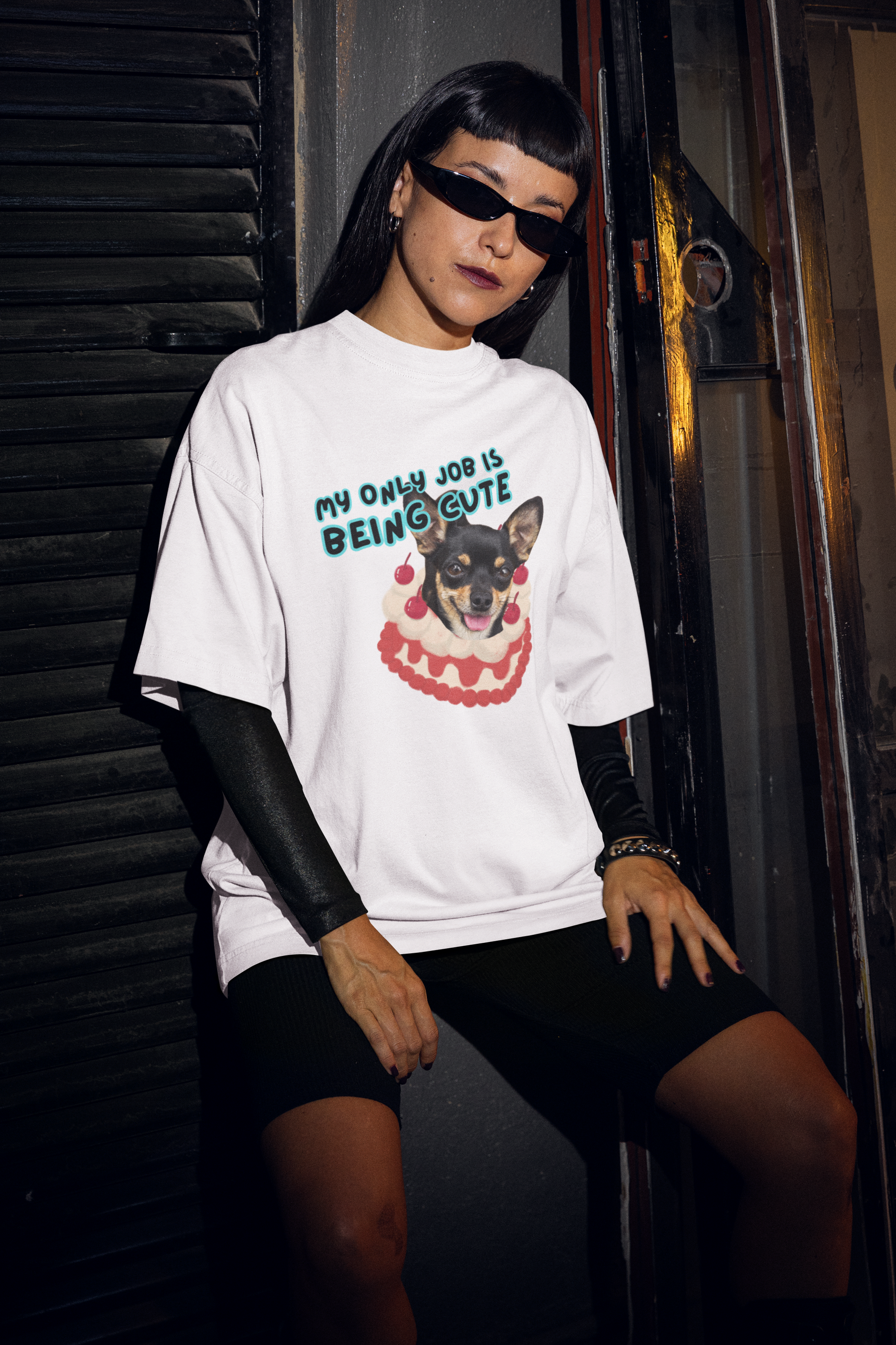 A women wearing Unisex Oversized "My Only Job Is Being Cute (16-Style)" White T-shirt, Front view - Black Chihuahua on Strawberries Vanilla Shortcake Design – Unique Fashion Tops - Front and Back Print - Oh Mine Words.