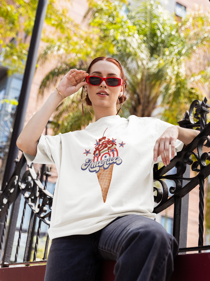 A women wearing unisex oversized "America on a cone (White)" t-shirt at front view - Unique Fashion Tops, 4th of July, Ice cream cone, whipped cream and star graphic - Front and Back Print - Oh Mine Words.