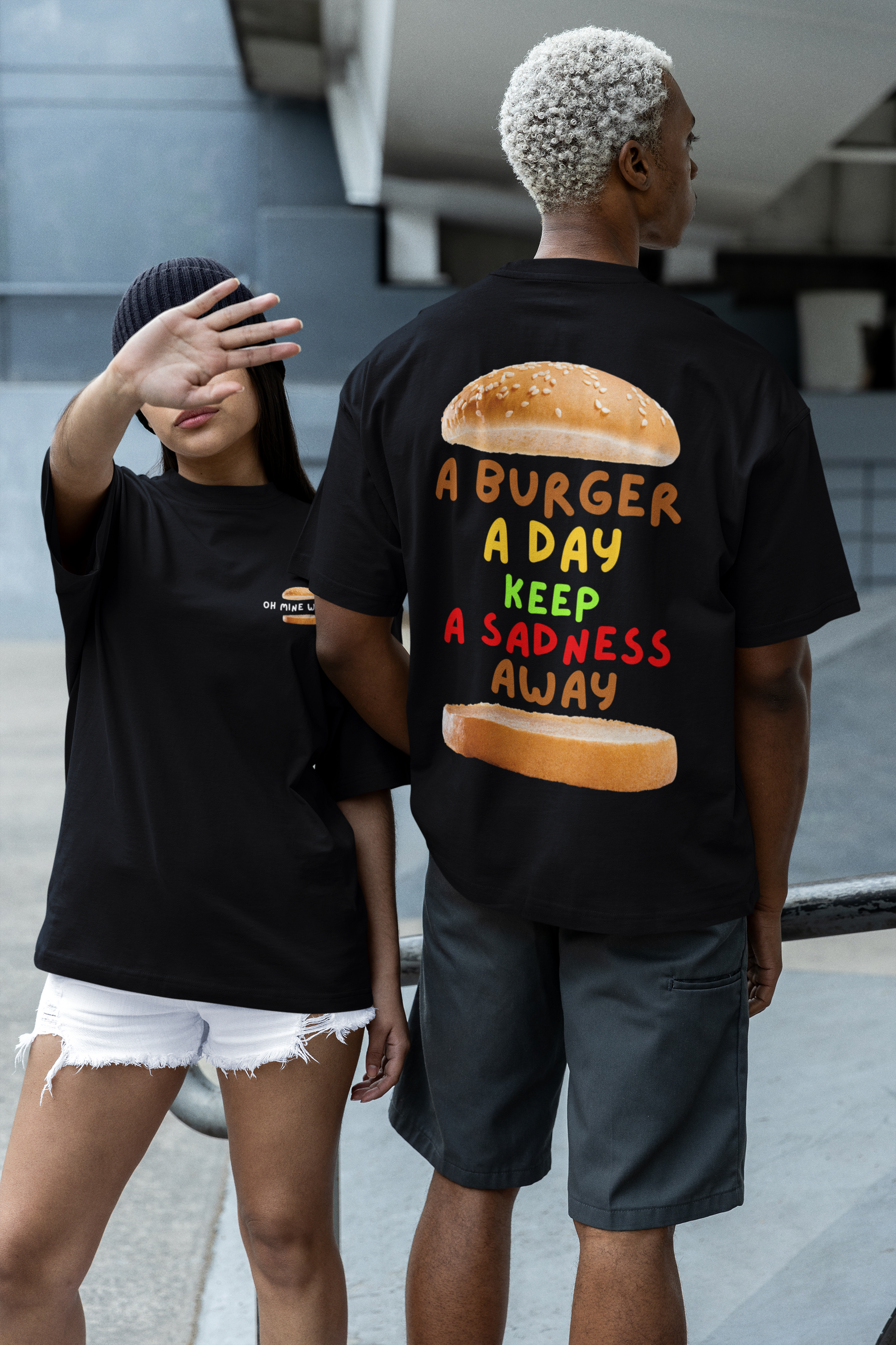 Women and men wearing unisex oversized "A Burger A Day Keep A Sadness Away" black t-shirt - unique fashion tops - funny quote, buns, burger, foodie, comfortable, front and back print - Oh Mine Words.